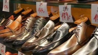 鞋店橱窗里的货架上摆着不同经典的皮革男鞋`各种颜色的鞋子，上面贴着价格标签